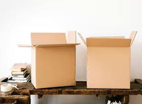 Photo of cardboard moving boxes and books on a table