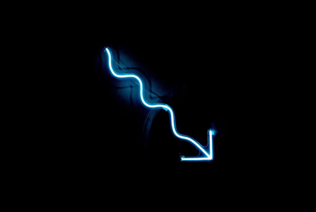 A blue neon sign on a black wall